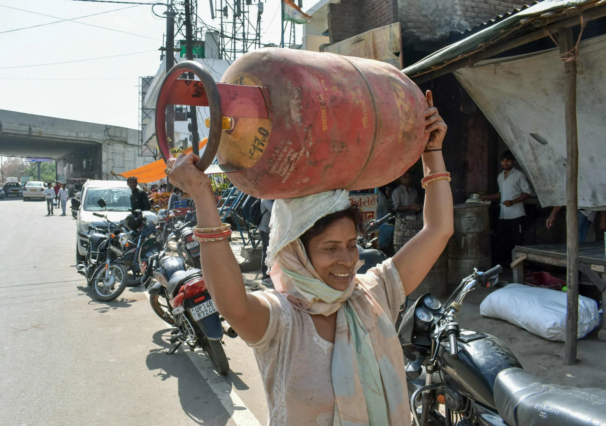 16 मार्च को जयपुर में एक महिला LPG सिलेंडर ले जाती हुई